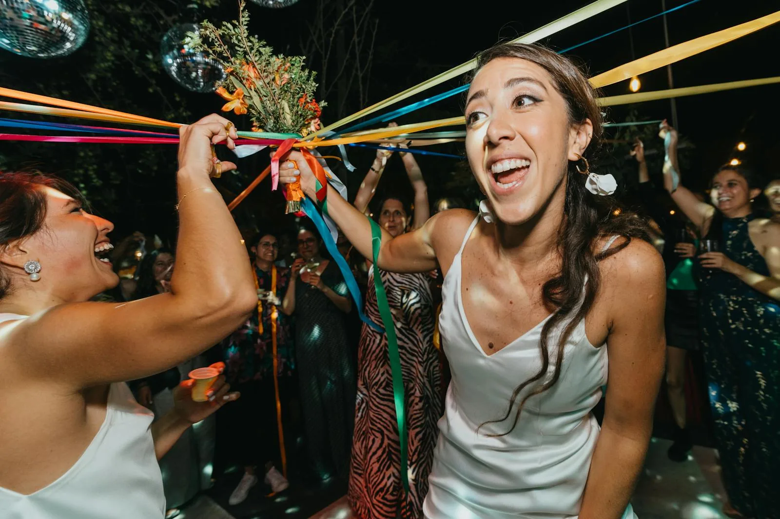 Excited guests reacting at a wedding bouquet toss
